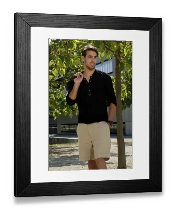 Framed Print : Man wearing shorts standing in front of a tree with a bag