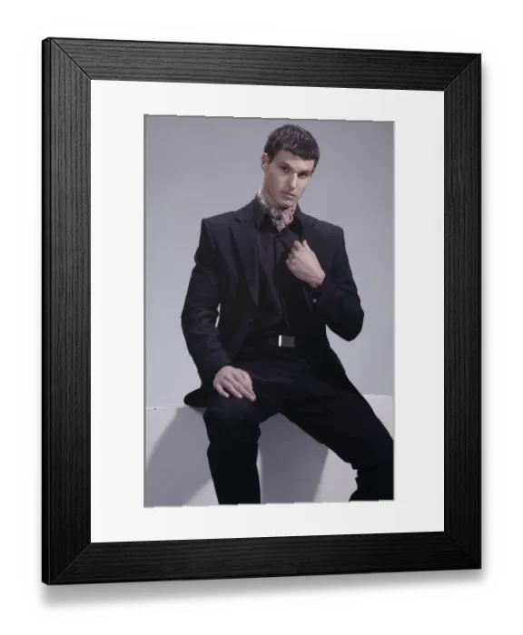 Framed Print : Fashion shot of a young man wearing a suit, sitting Framed Print : Fashion shot of a young man wearing a suit, sitting