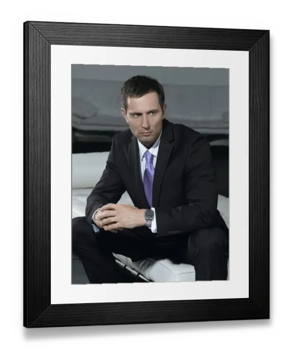 Framed Print : Businessman wearing a suit, sitting on a white sofa Framed Print : Businessman wearing a suit, sitting on a white sofa