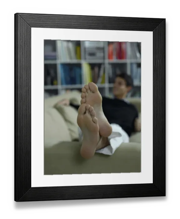 Framed Print : Bare feet of a man lying on a sofa Framed Print : Bare feet of a man lying on a sofa