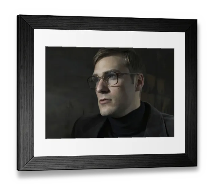 Framed Print : Student wearing a suit and glasses, sitting in front of a painting Framed Print : Student wearing a suit and glasses, sitting in front of a painting