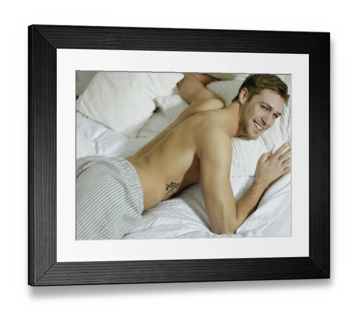 Framed Print : Charming bare chested man wearing pyjamas lying in bed, smiling Framed Print : Charming bare chested man wearing pyjamas lying in bed, smiling