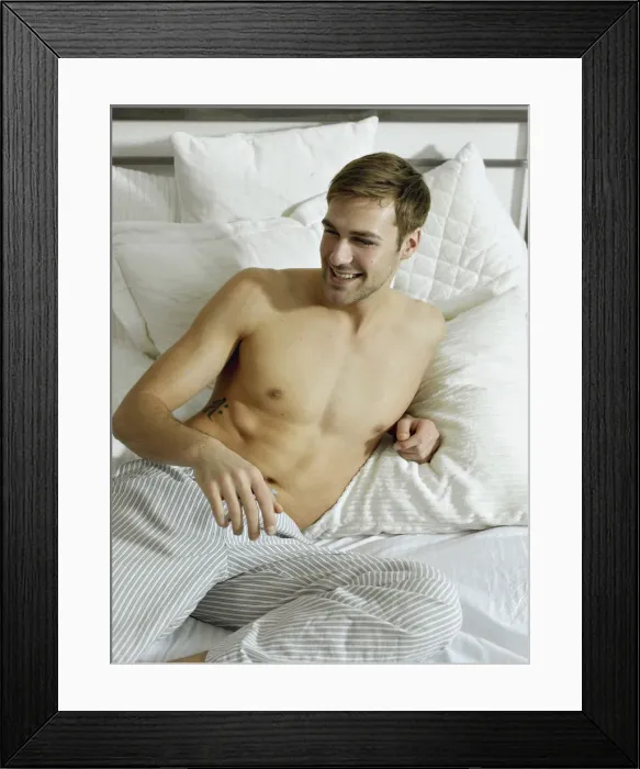 Framed Print : Charming bare chested man wearing pyjamas lying in bed, smiling Framed Print : Charming bare chested man wearing pyjamas lying in bed, smiling