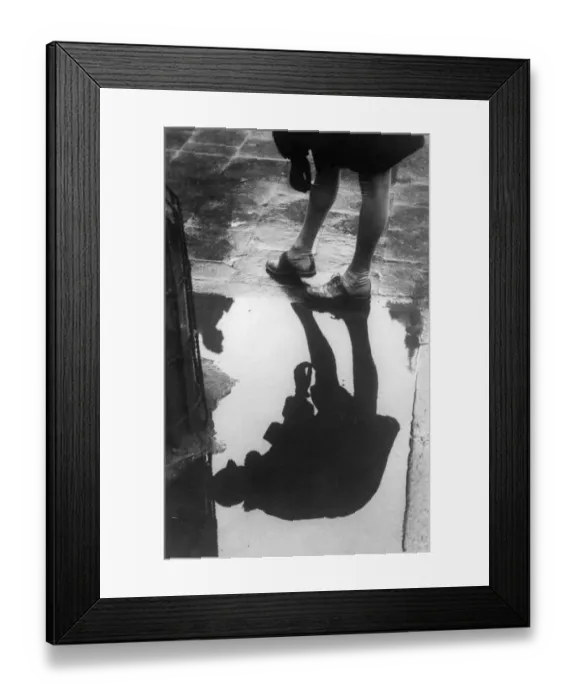 Framed Print : Saggy. circa 1930: A girl pulling up her stockings is reflected in a puddle Framed Print : Saggy. circa 1930: A girl pulling up her stockings is reflected in a puddle