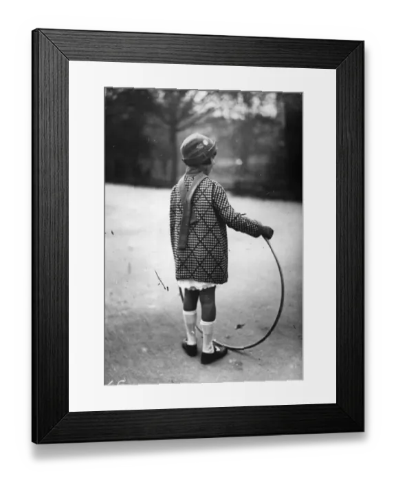 Framed Print : Hoop La. circa 1930: A girl plays with a hoop in a park Framed Print : Hoop La. circa 1930: A girl plays with a hoop in a park