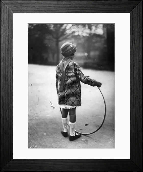 Framed Print : Hoop La. circa 1930: A girl plays with a hoop in a park Framed Print : Hoop La. circa 1930: A girl plays with a hoop in a park