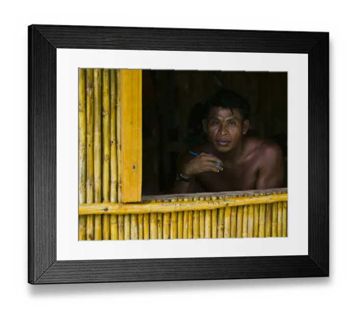 Framed Print : Man looking out window of bamboo hut, portrait Framed Print : Man looking out window of bamboo hut, portrait