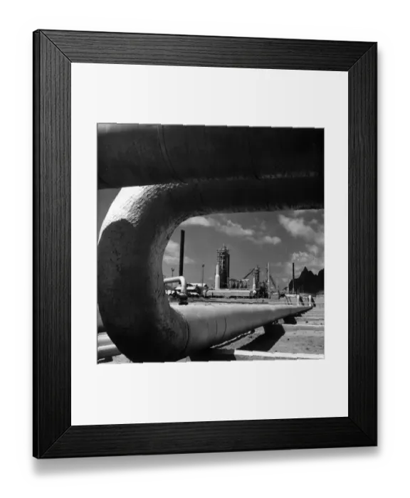 Framed Print : Oil Pipe. 29th April 1958: A section of pipe frames the crude oil distillation Framed Print : Oil Pipe. 29th April 1958: A section of pipe frames the crude oil distillation