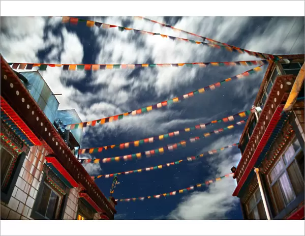 Tibetan prayer flags fly in night sky over house
