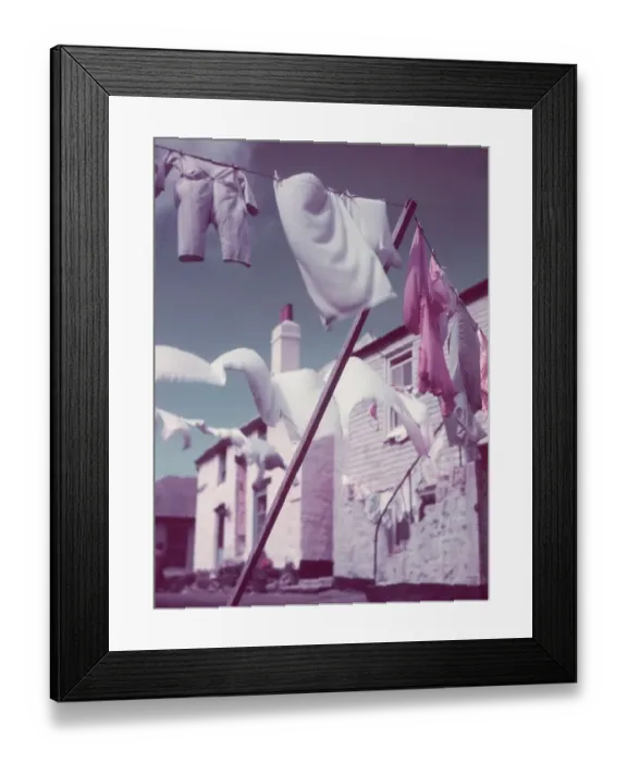 Framed Print : Blustery. circa 1957: Washing lines strung across a village street Framed Print : Blustery. circa 1957: Washing lines strung across a village street