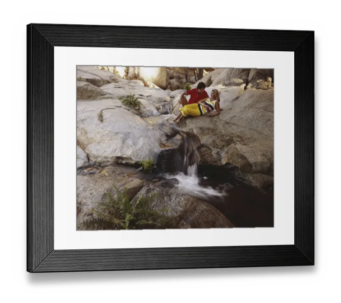 Framed Print : Couple leaning on rock above waterfall Framed Print : Couple leaning on rock above waterfall