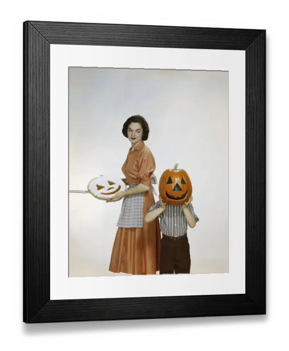 Framed Print : Woman with pie looking at child holding halloween pumpkin, smiling Framed Print : Woman with pie looking at child holding halloween pumpkin, smiling
