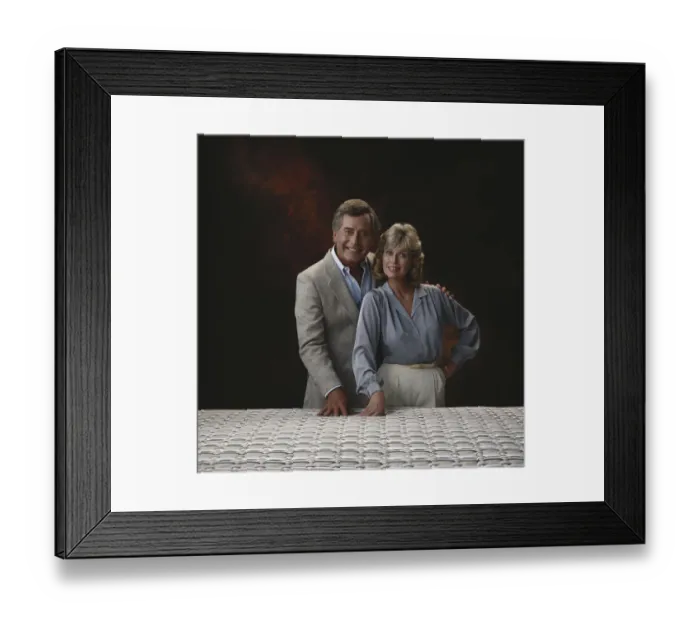 Framed Print : Mature couple standing against black background, smiling, portrait Framed Print : Mature couple standing against black background, smiling, portrait