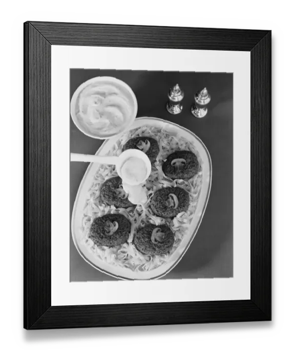 Framed Print : Savoury sauce being poured on cutlet with pasta, close-up Framed Print : Savoury sauce being poured on cutlet with pasta, close-up
