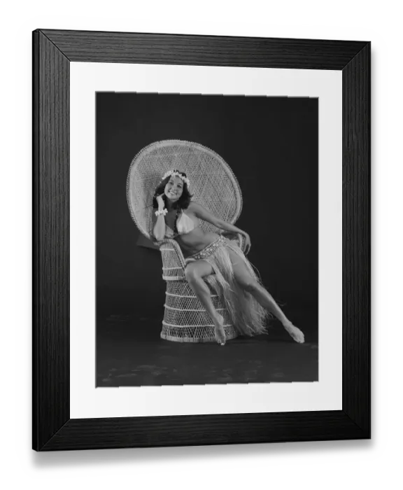 Framed Print : Young woman hula dancer in traditional clothing sitting on wicker chair, smiling, portrait Framed Print : Young woman hula dancer in traditional clothing sitting on wicker chair, smiling, portrait