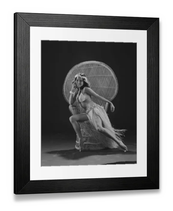 Framed Print : Young woman hula dancer in traditional clothing sitting on wicker chair, smiling, portrait Framed Print : Young woman hula dancer in traditional clothing sitting on wicker chair, smiling, portrait