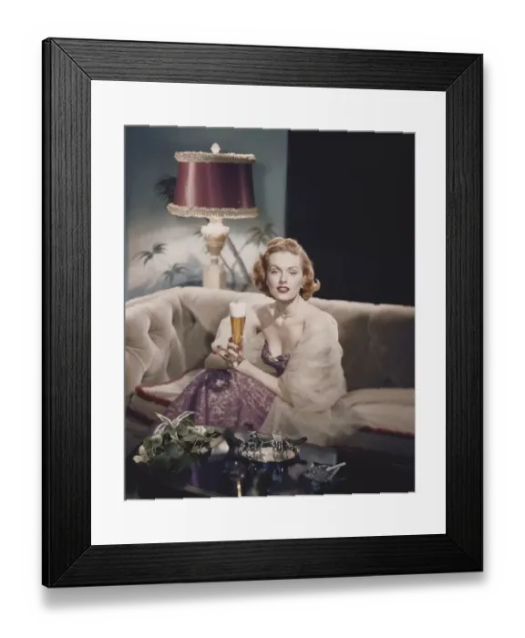 Framed Print : Portrait of a young woman sitting holding a beer glass Framed Print : Portrait of a young woman sitting holding a beer glass