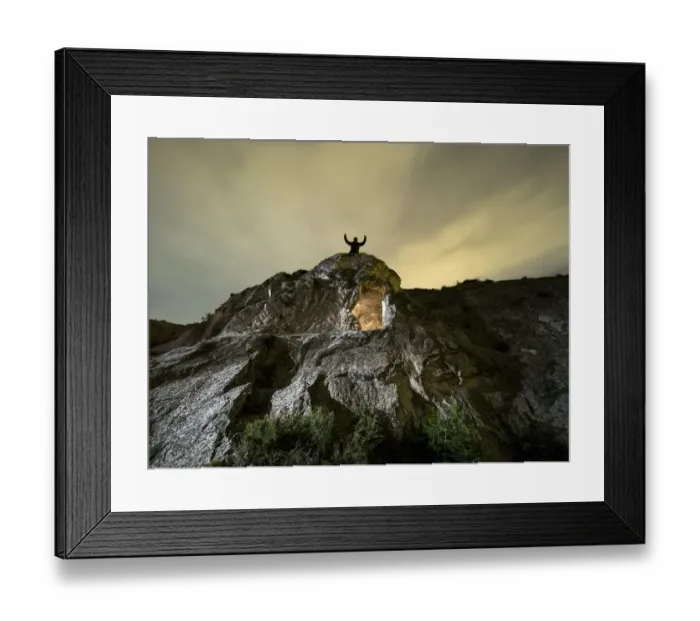 Framed Print : Cave excavated in the rock, on the top of a mountain with a man raises with the arms raised in the night Framed Print : Cave excavated in the rock, on the top of a mountain with a man raises with the arms raised in the night