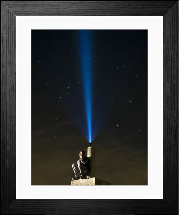 Framed Print : Man on top of a mountain, desperate hands on the lost face at night with a flashlight signal Framed Print : Man on top of a mountain, desperate hands on the lost face at night with a flashlight signal