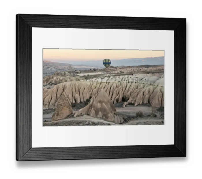 Framed Print : Hot air balloon flying over rock landscape at Cappadocia Turkey