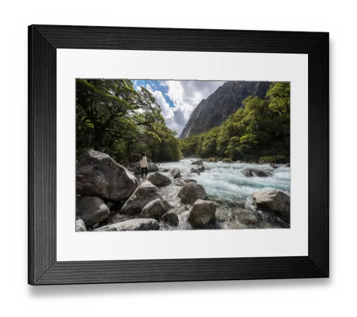 Framed Print : The women stands on a stone in the midst of watercourse with mountains in Milford highway Framed Print : The women stands on a stone in the midst of watercourse with mountains in Milford highway