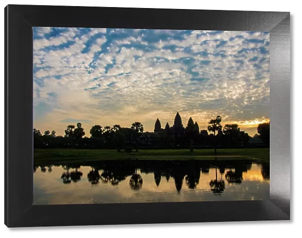 Angkor Wat temple at sunrise reflecting in water