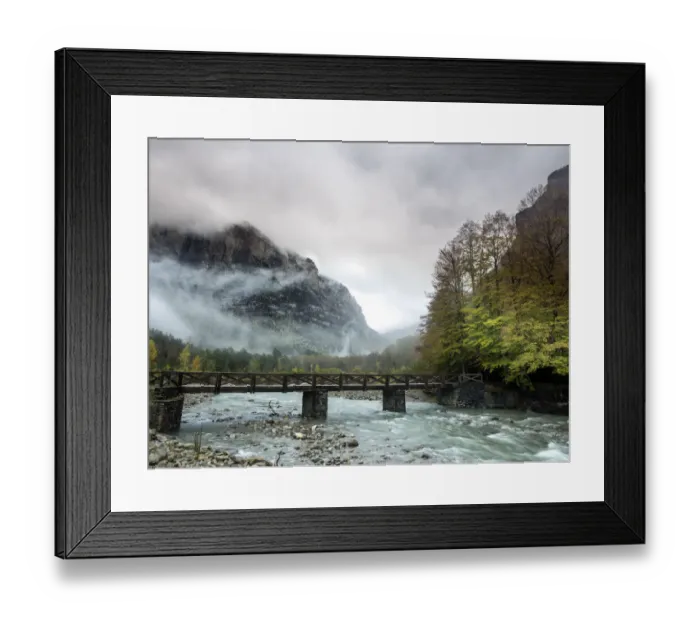Framed Print : Torrent of high mountain with a bridge of wood in a valley with mountains and forests in autumn