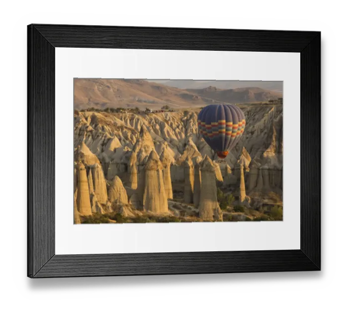 Framed Print : Hot air balloon flying over rock landscape at Cappadocia Turkey Framed Print : Hot air balloon flying over rock landscape at Cappadocia Turkey