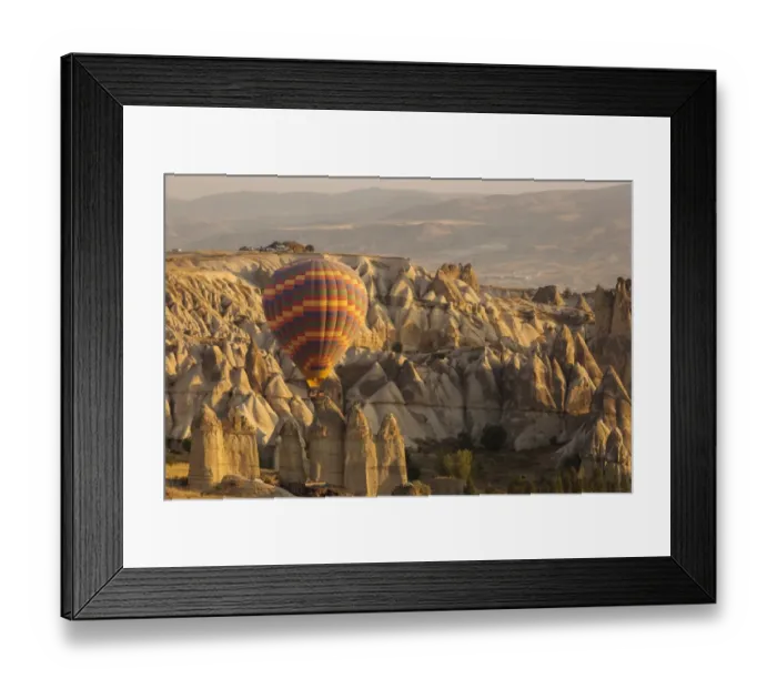 Framed Print : Hot air balloon flying over rock landscape at Cappadocia Turkey Framed Print : Hot air balloon flying over rock landscape at Cappadocia Turkey