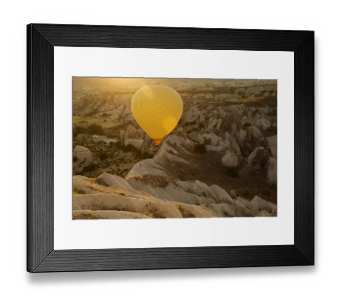 Framed Print : Hot air balloon flying over rock landscape at Cappadocia Turkey