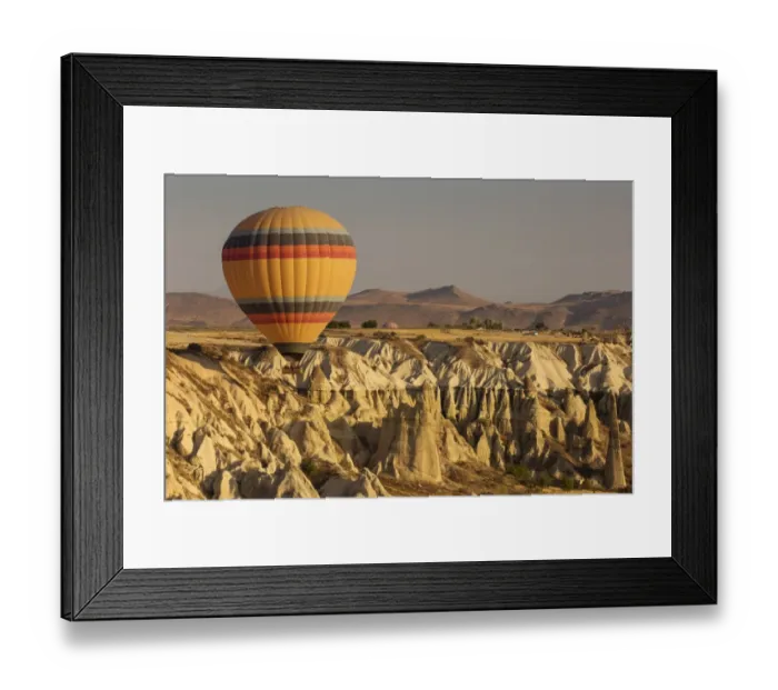 Framed Print : Hot air balloon flying over rock landscape at Cappadocia Turkey Framed Print : Hot air balloon flying over rock landscape at Cappadocia Turkey