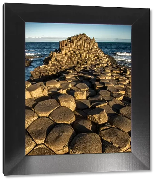 The rising sun on a rock formation called the Giants Causeway, County Antrim, Northern Ireland