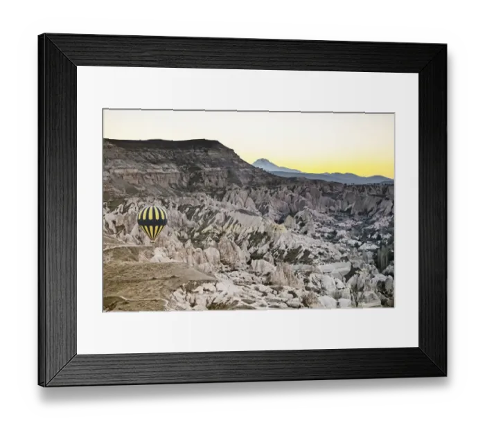 Framed Print : Hot air balloon flying over rock landscape at Cappadocia, Turkey Framed Print : Hot air balloon flying over rock landscape at Cappadocia, Turkey