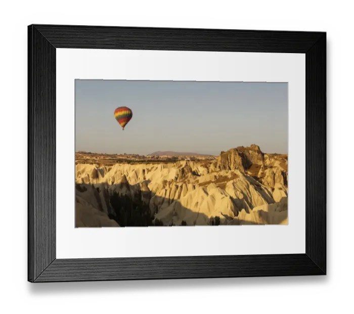 Framed Print : Hot air balloon flying over rock landscape at Cappadocia Turkey Framed Print : Hot air balloon flying over rock landscape at Cappadocia Turkey