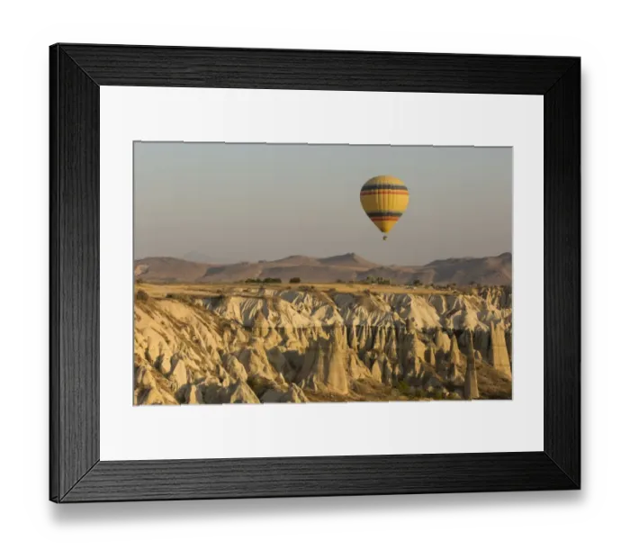 Framed Print : Hot air balloon flying over rock landscape at Cappadocia Turkey Framed Print : Hot air balloon flying over rock landscape at Cappadocia Turkey