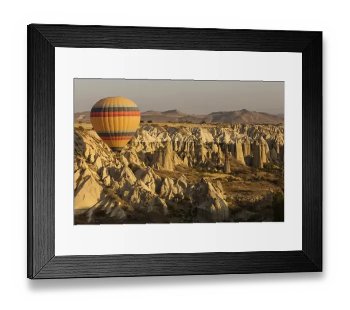 Framed Print : Hot air balloon flying over rock landscape at Cappadocia Turkey Framed Print : Hot air balloon flying over rock landscape at Cappadocia Turkey