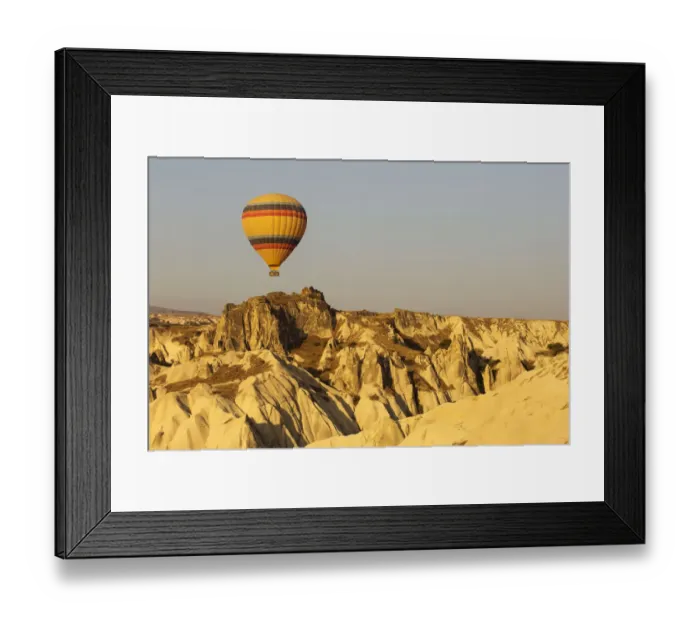 Framed Print : Hot air balloon flying over rock landscape at Cappadocia Turkey Framed Print : Hot air balloon flying over rock landscape at Cappadocia Turkey