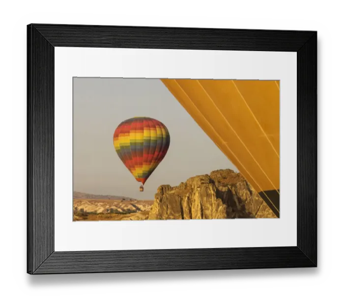 Framed Print : Hot air balloon flying over rock landscape at Cappadocia Turkey