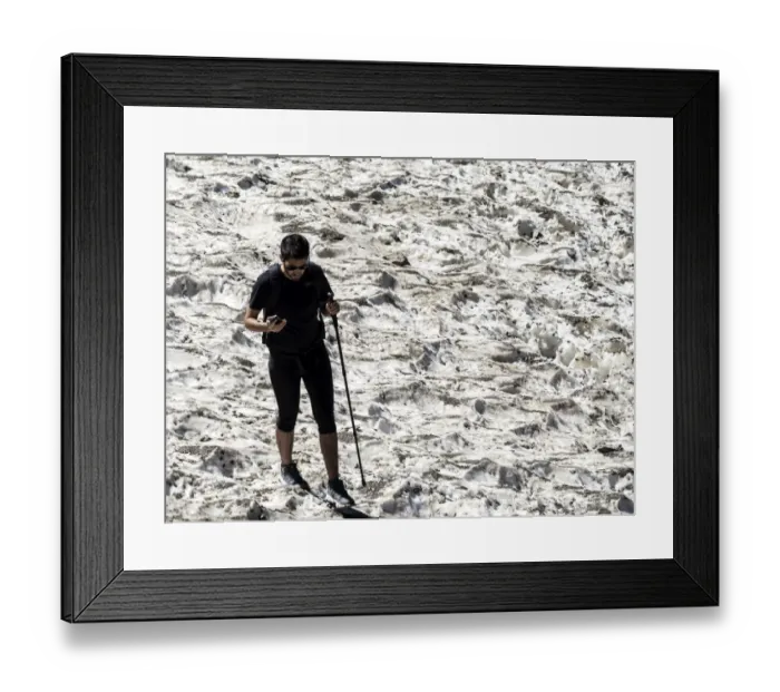 Framed Print : Mountaineer on a glacier snow on a break using the mobile phone