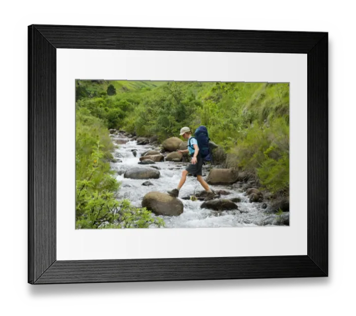 Framed Print : Hiker Boulder Hopping Across a River