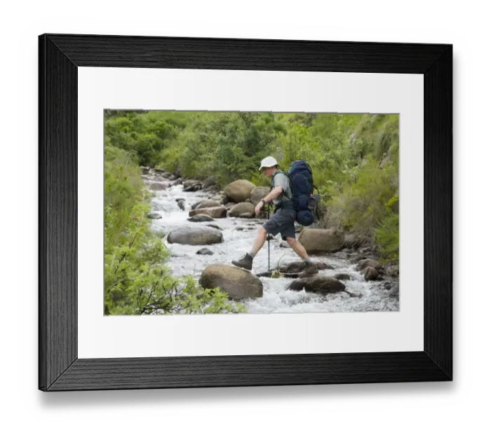 Framed Print : Hiker Boulder Hopping Across a River Framed Print : Hiker Boulder Hopping Across a River