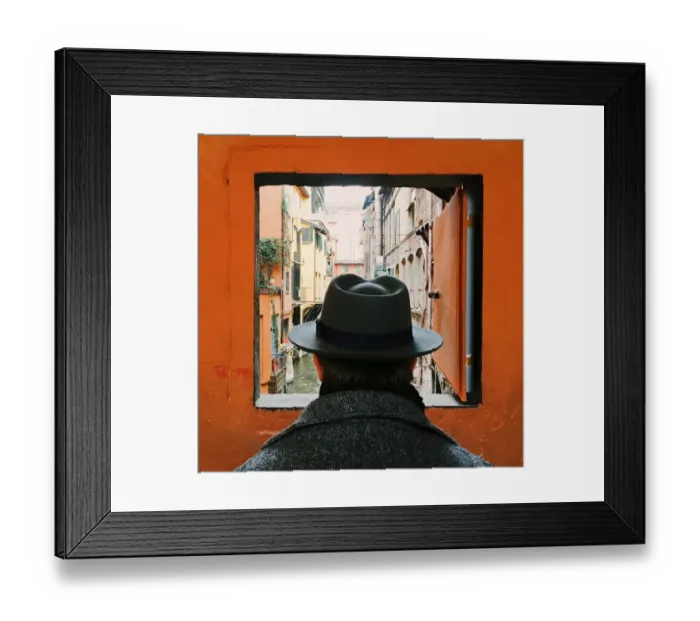 Framed Print : Man in hat looking at the canal through the window in Bologna, Italy Framed Print : Man in hat looking at the canal through the window in Bologna, Italy