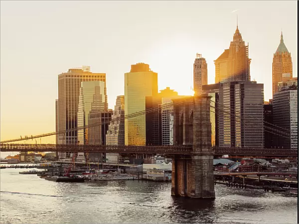 Sunset over Brooklyn Bridge and skyline of Manhattan Financial District in Downtown, New York City, NY, United States