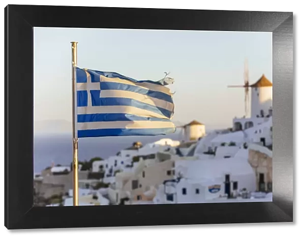 Oia village in Santorini and flag of Greece
