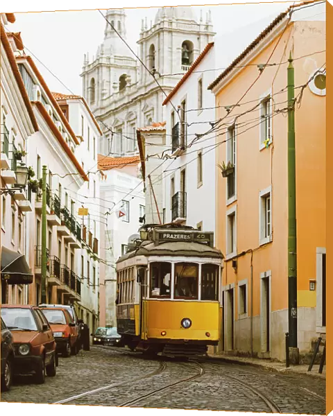 Famous yellow tram on the narrow streets of Alfama district, Lisbon, Portugal