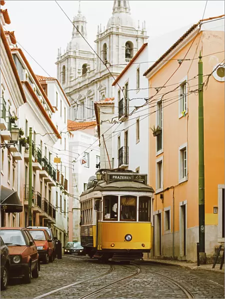 Famous yellow tram on the narrow streets of Alfama district, Lisbon, Portugal