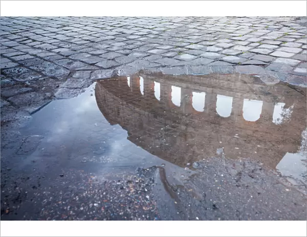 Colosseum reflected in puddle, Rome, Italy