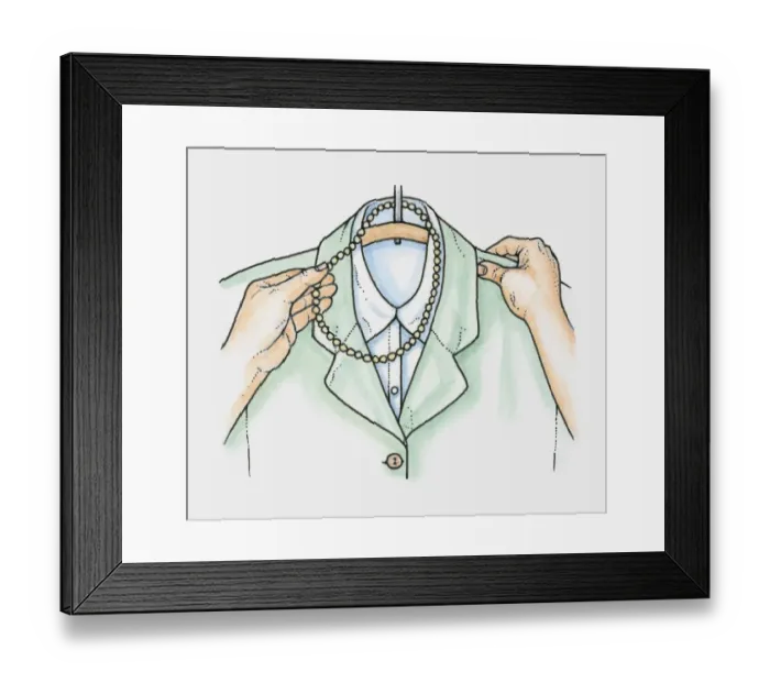 Framed Print : Hands placing necklace of beads over hanger holding jacket and blouse Framed Print : Hands placing necklace of beads over hanger holding jacket and blouse