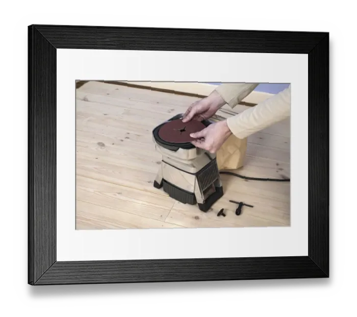 Framed Print : Man using hands to position circle of sand paper on edging sander Framed Print : Man using hands to position circle of sand paper on edging sander