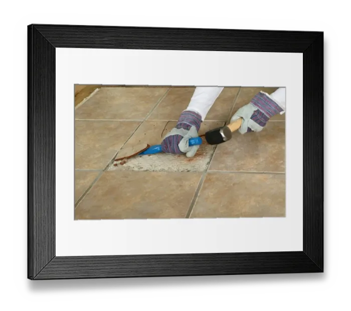 Framed Print : Man using club hammer and chisel to remove marble tile from floor, close-up Framed Print : Man using club hammer and chisel to remove marble tile from floor, close-up